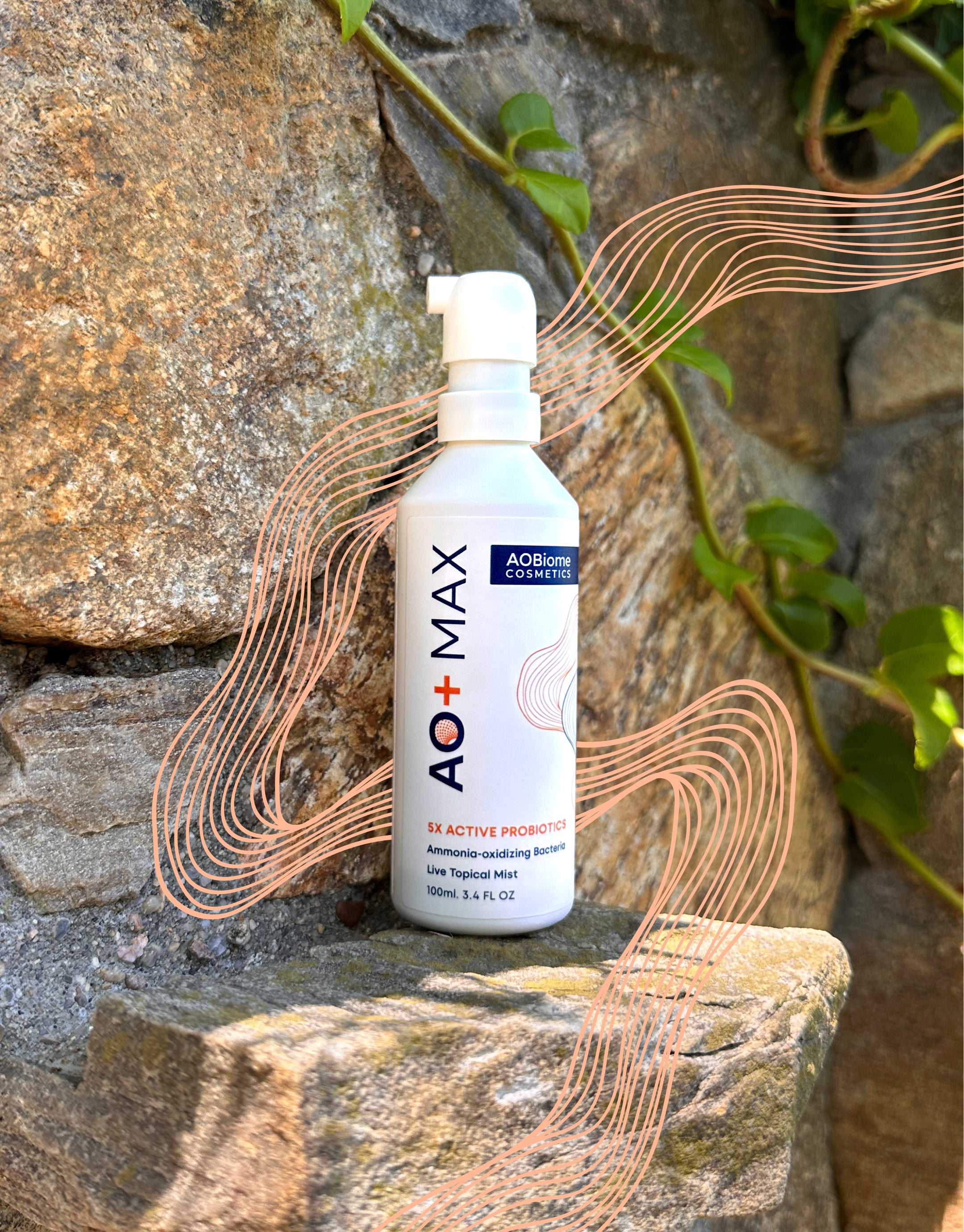 A white pump bottle of AO+ MAX probiotic powder stands on a stone surface outdoors against a rock wall with green ivy