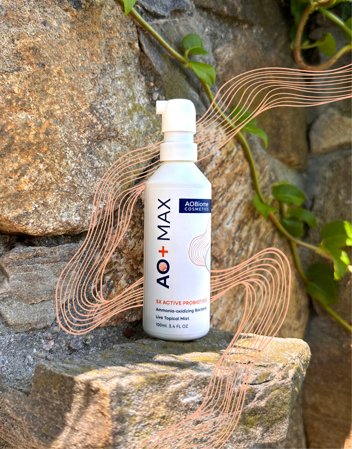 A white pump bottle of AO+ MAX probiotic powder stands on a stone surface outdoors against a rock wall with green ivy